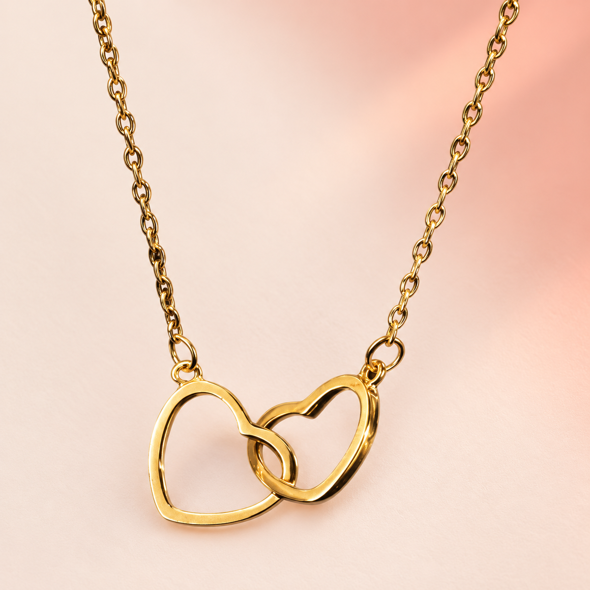 Gold-tone fine-chain necklace with two interlinked open hearts