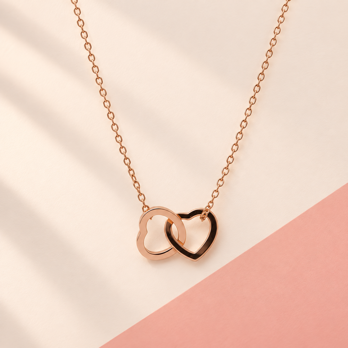 Rose-gold-tone necklace with two interlinked open heart shapes