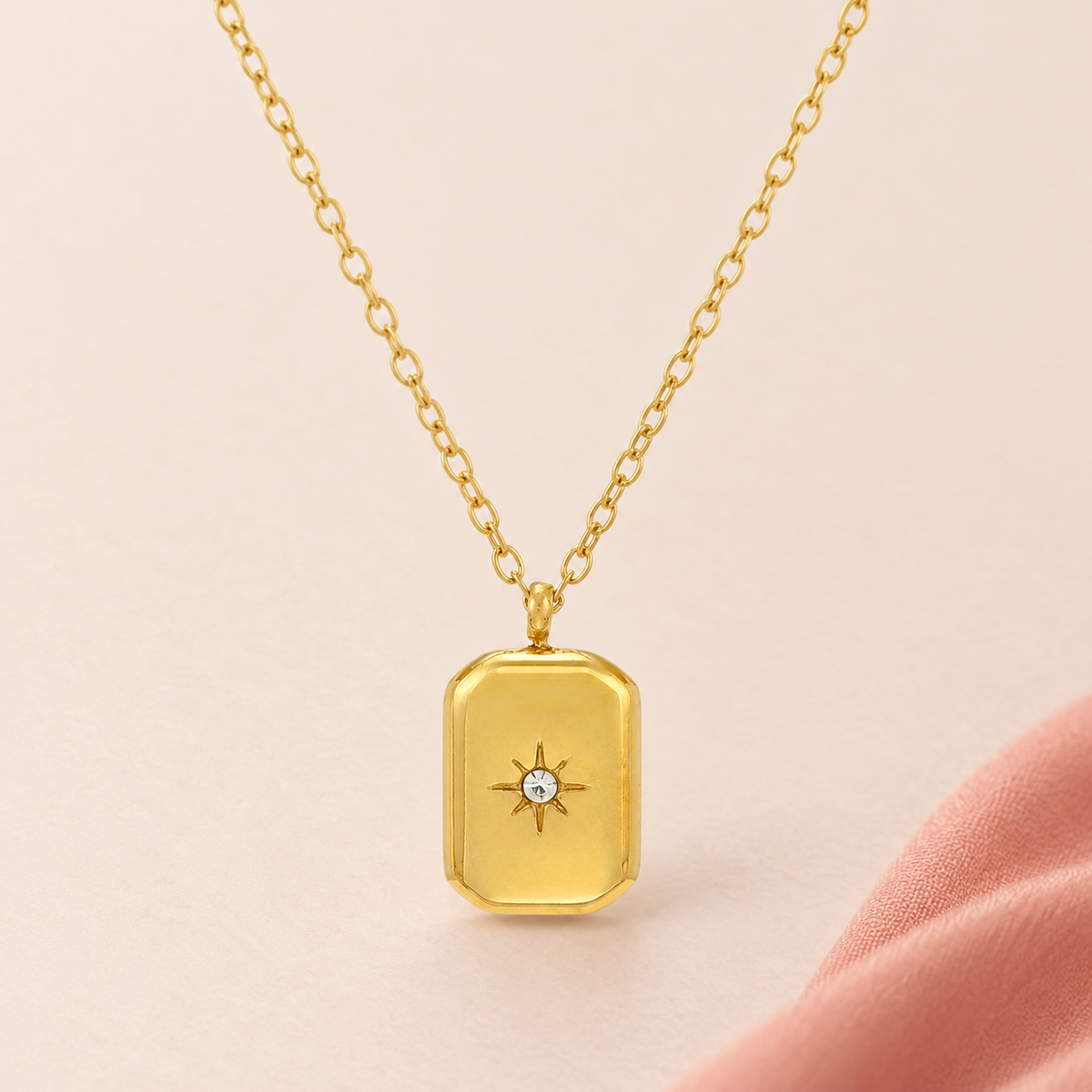 Gold-tone rectangular pendant necklace with a central star-shaped accent