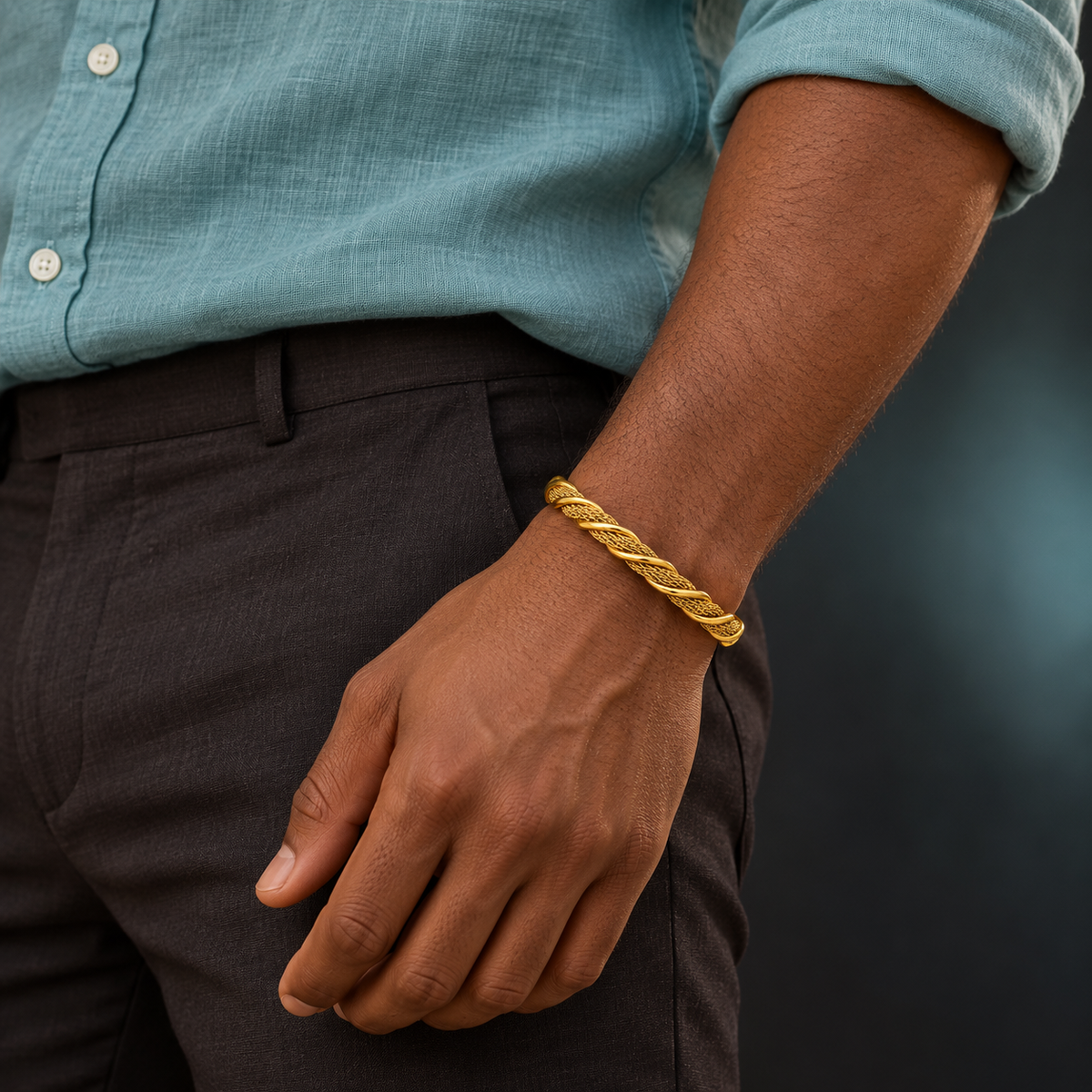 Gold-tone twisted mesh cuff worn with an aqua shirt