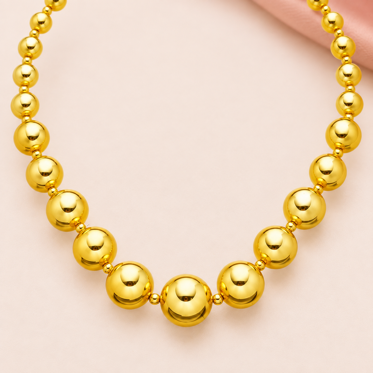 Gold-tone necklace with graduated round beads and small spacers
