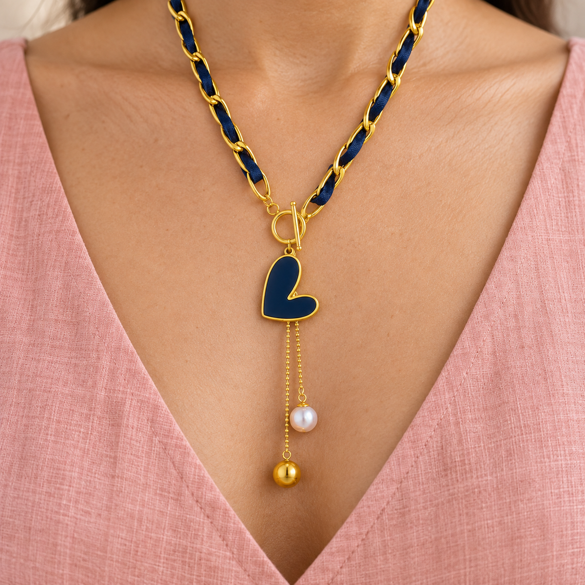 Navy ribbon-weave necklace with gold-tone links, heart-shaped drop and two bead-ended tails