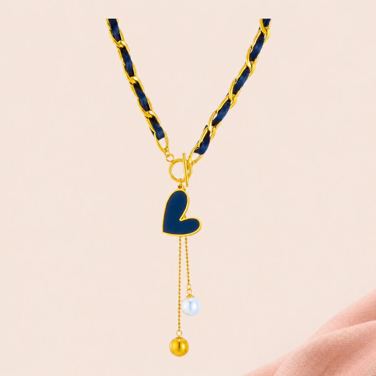 Navy ribbon-weave necklace with gold-tone links, heart-shaped drop and two bead-ended tails