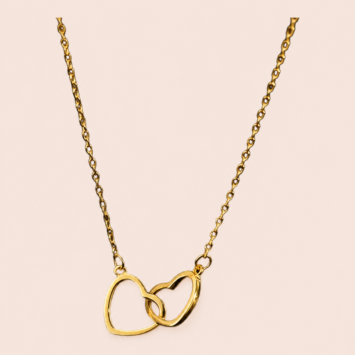 Gold-tone fine-chain necklace with two interlinked open hearts