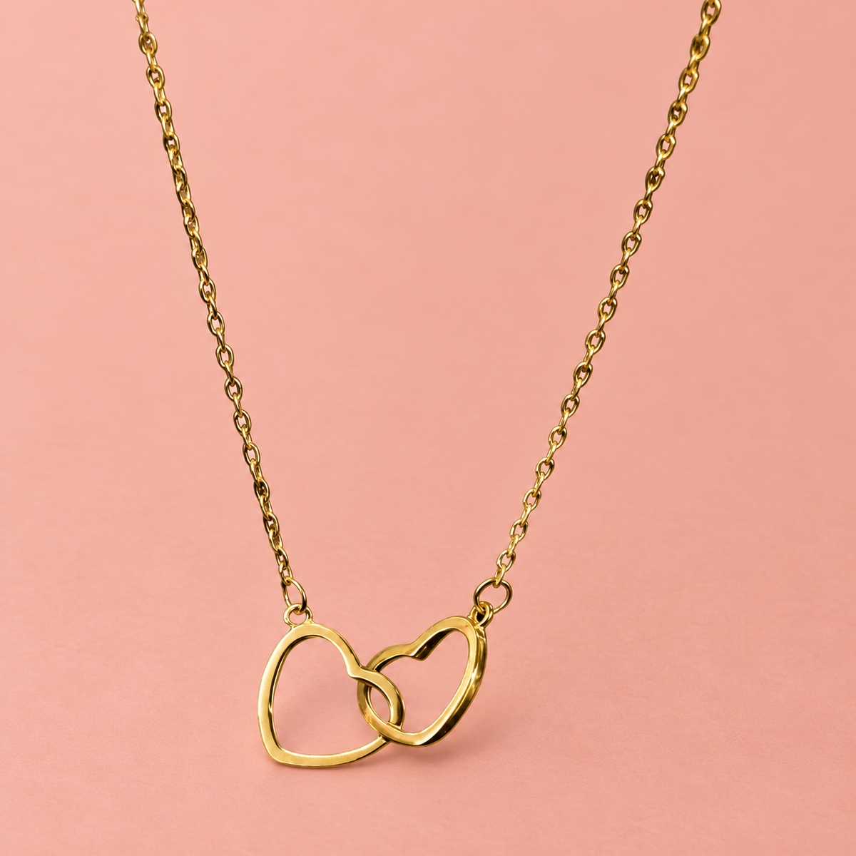 Gold-tone fine-chain necklace with two interlinked open hearts