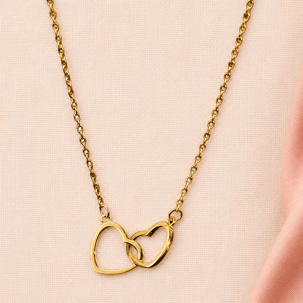 Gold-tone fine-chain necklace with two interlinked open hearts