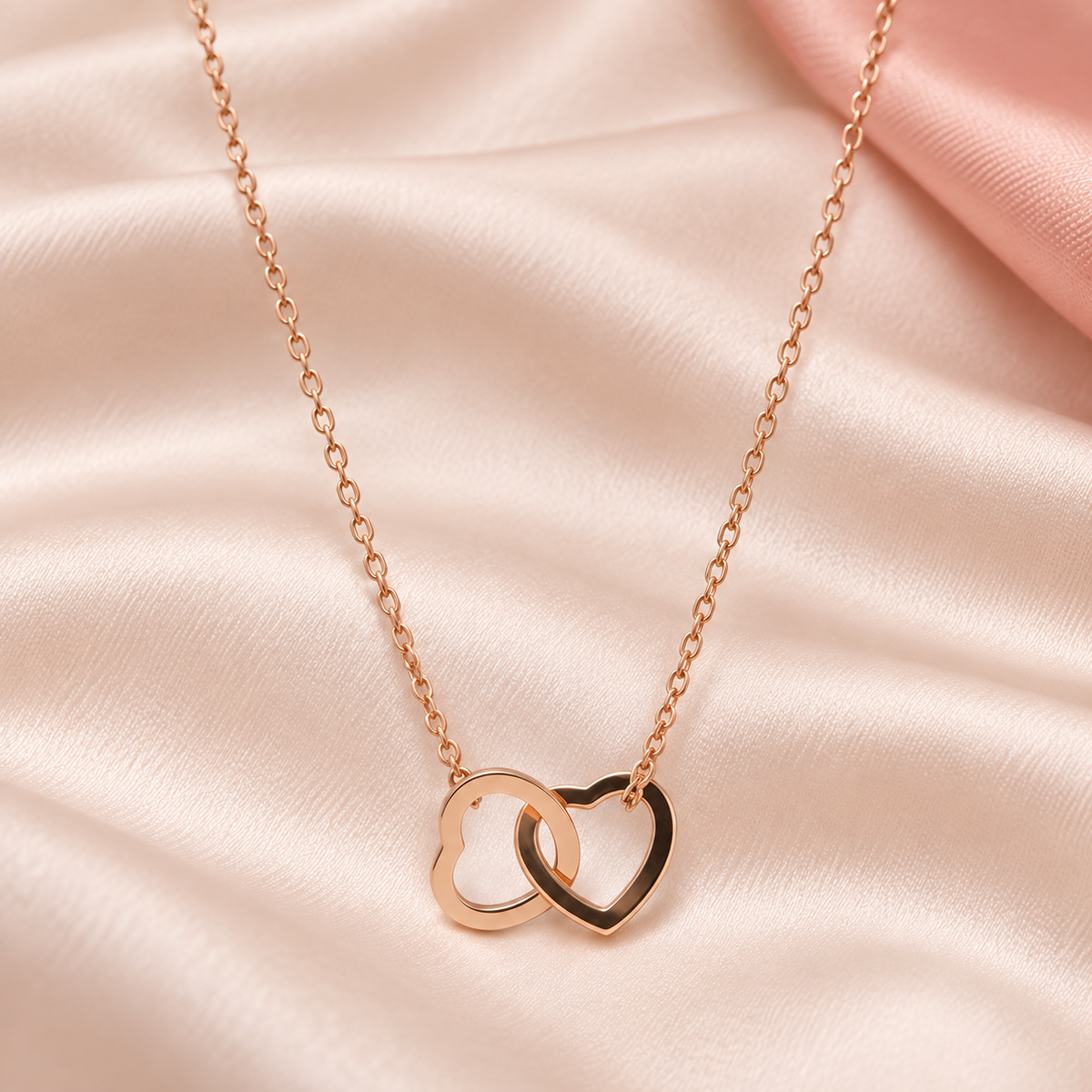 Rose-gold-tone necklace with two interlinked open heart shapes