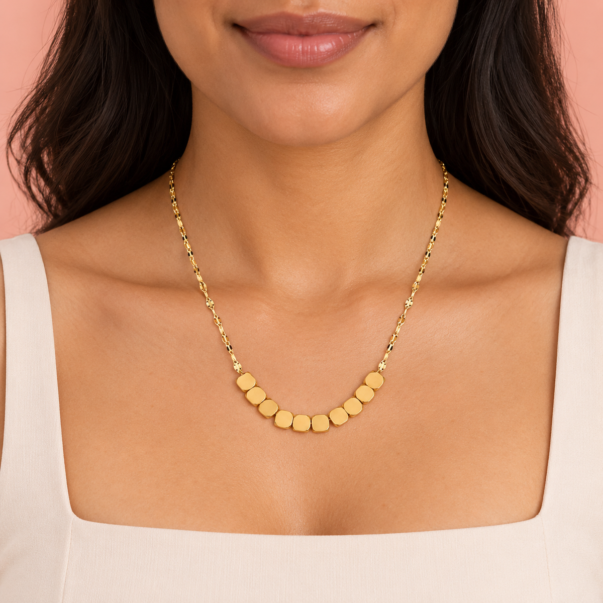 Gold-tone necklace with ten rounded-square beads at the front