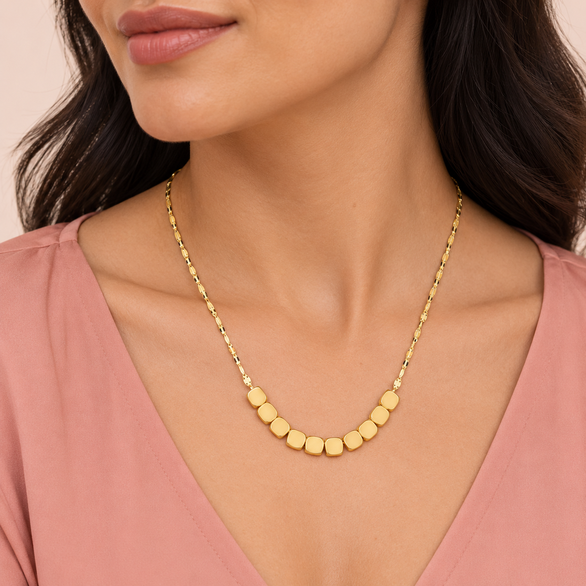 Gold-tone necklace with ten rounded-square beads at the front