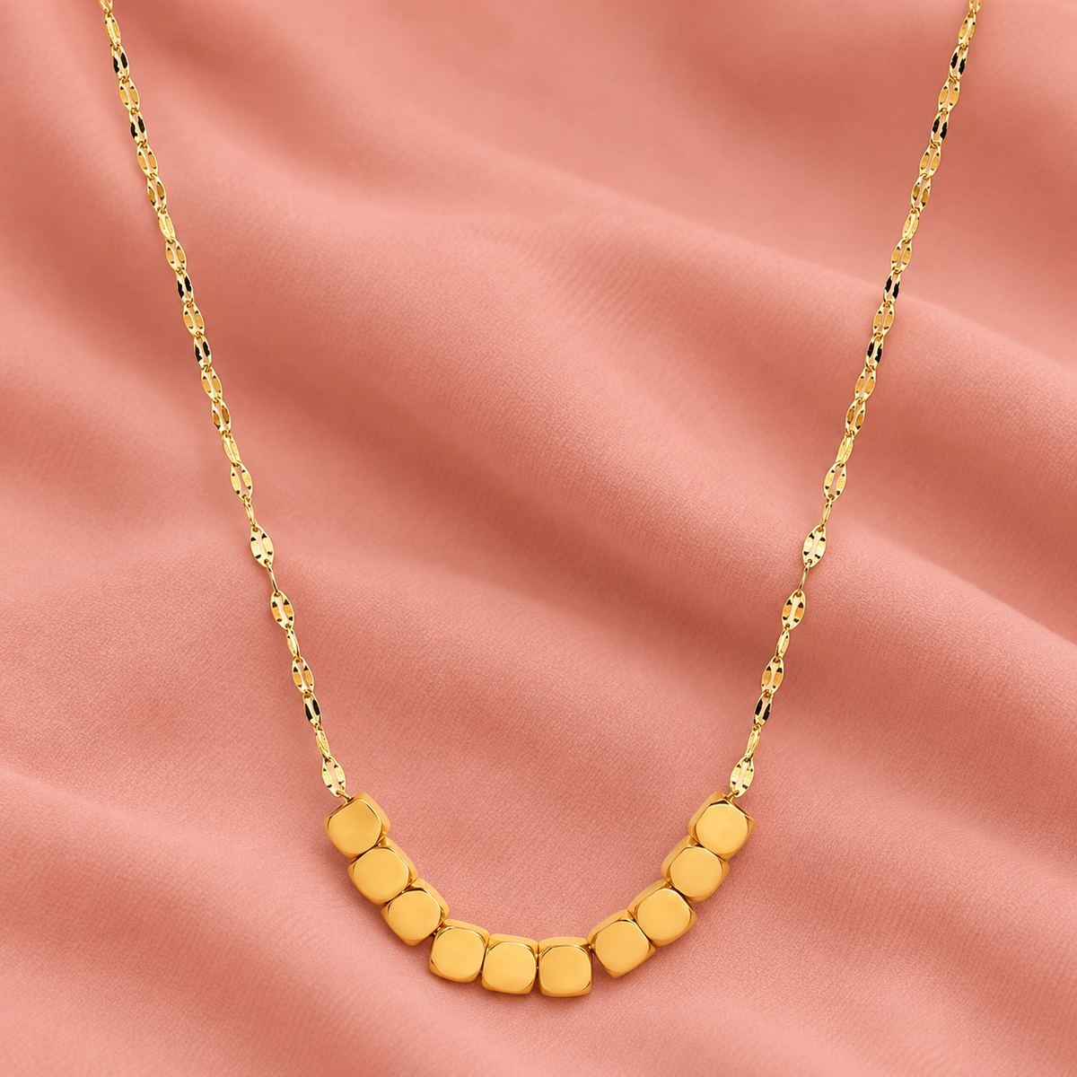 Gold-tone necklace with ten rounded-square beads at the front