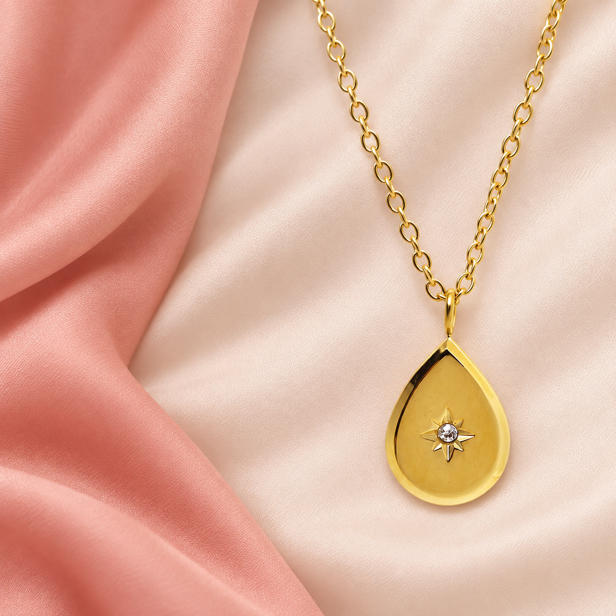 Gold-tone teardrop pendant necklace with a star-shaped central accent