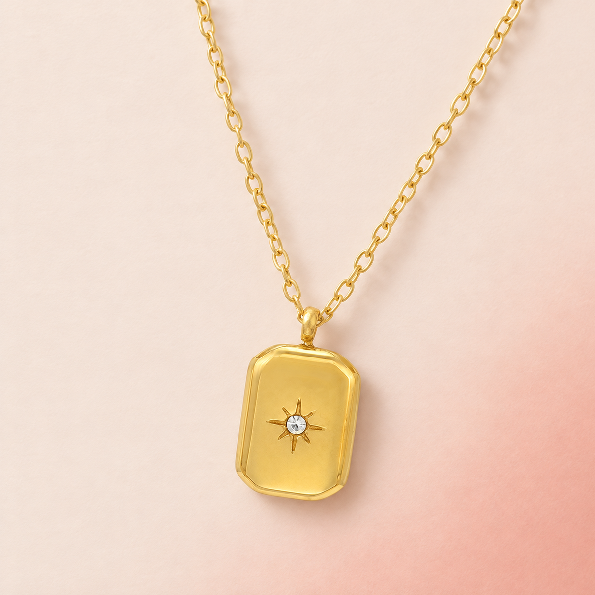 Gold-tone rectangular pendant necklace with a central star-shaped accent
