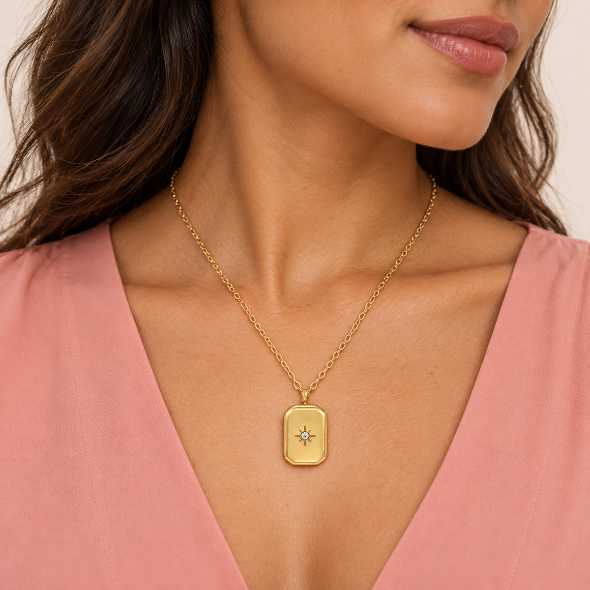 Gold-tone rectangular pendant necklace with a central star-shaped accent