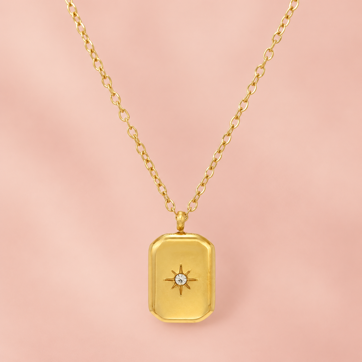 Gold-tone rectangular pendant necklace with a central star-shaped accent