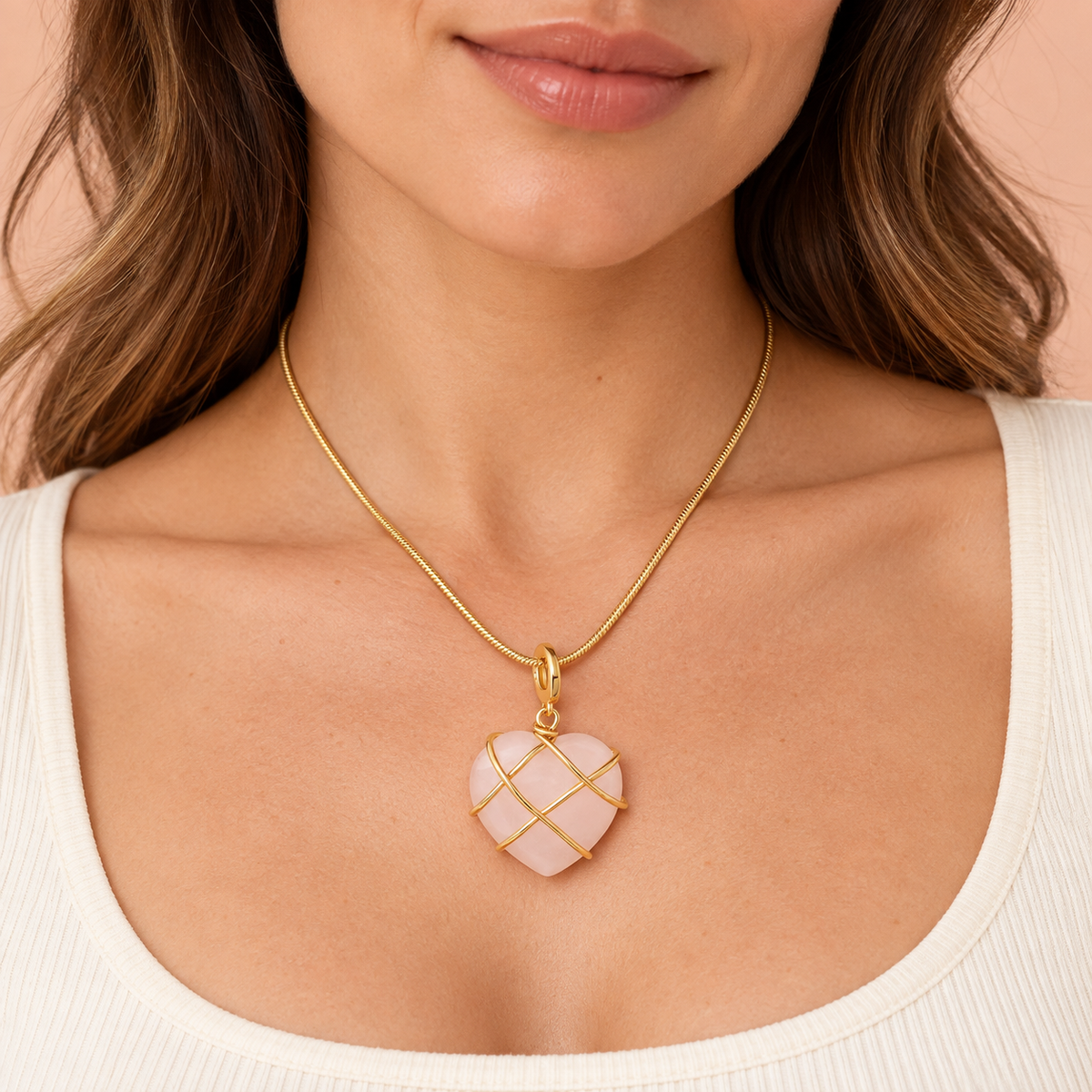 Pale-pink heart pendant necklace with crossing gold-tone bands