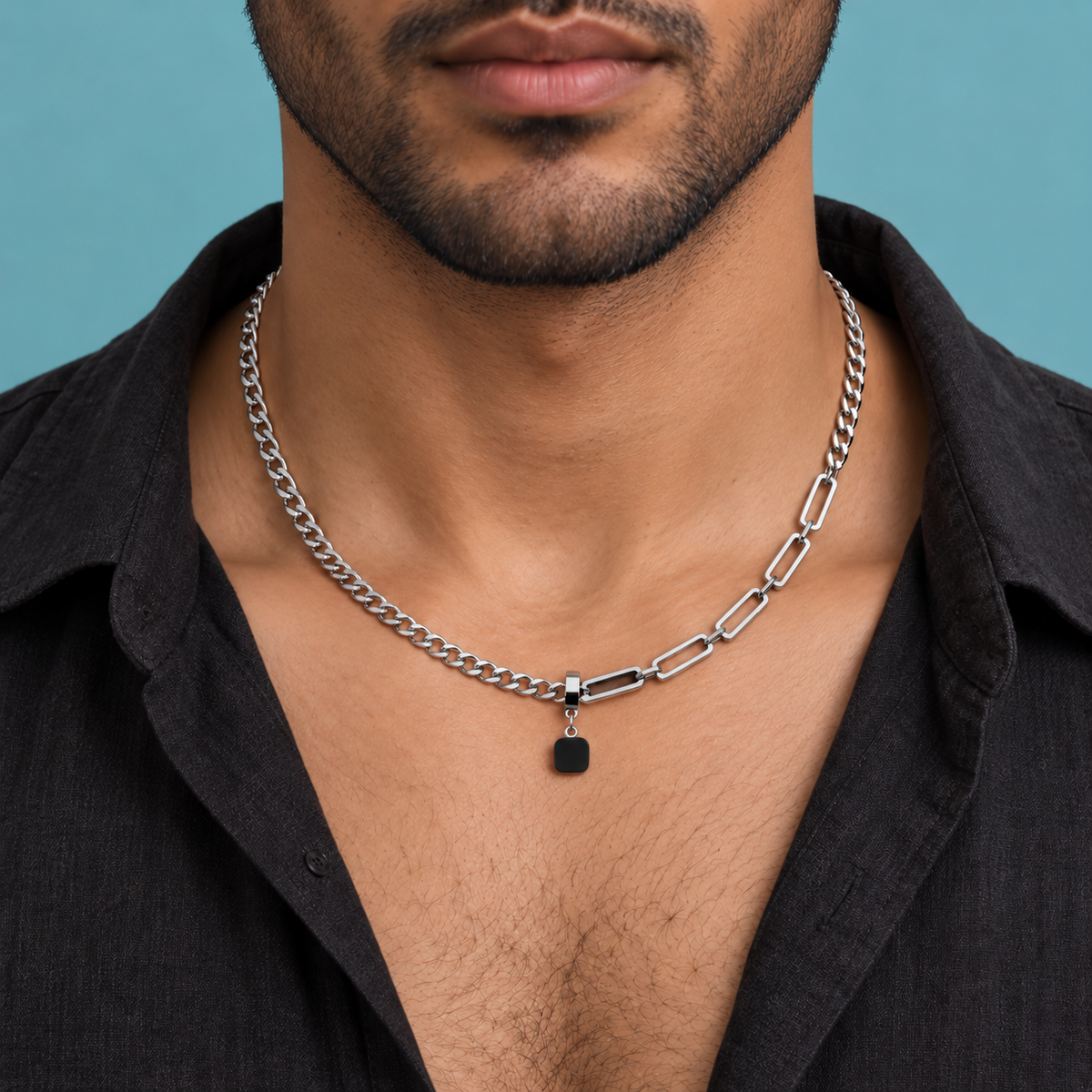 Black rounded-square pendant necklace shown with a black open-collar shirt