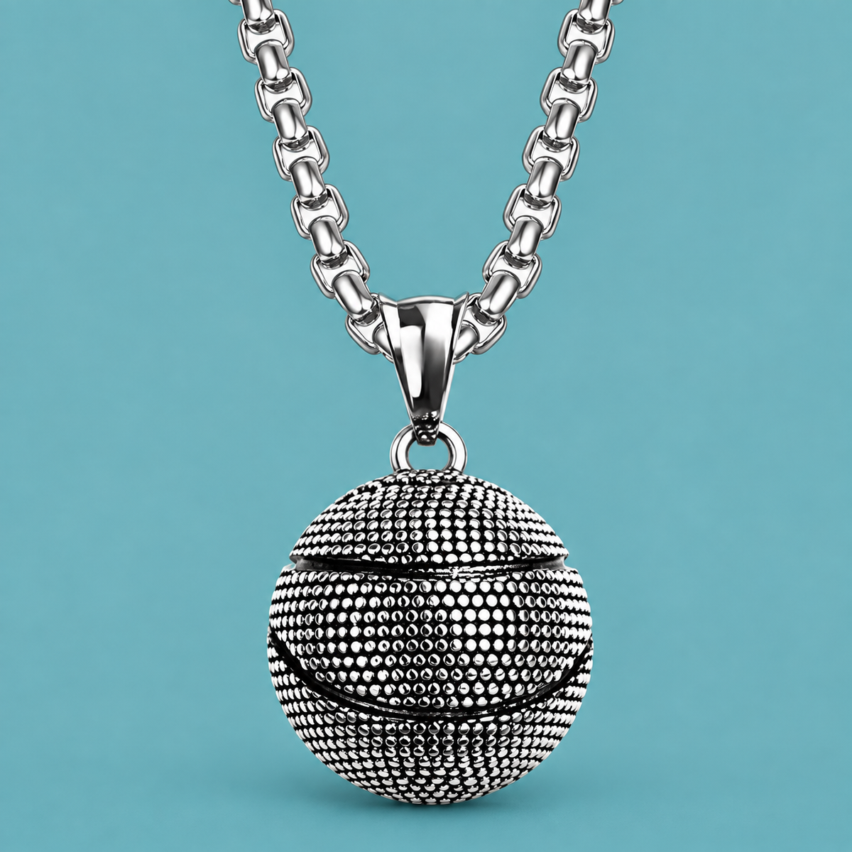 Silver-tone textured ball pendant necklace on an aqua background