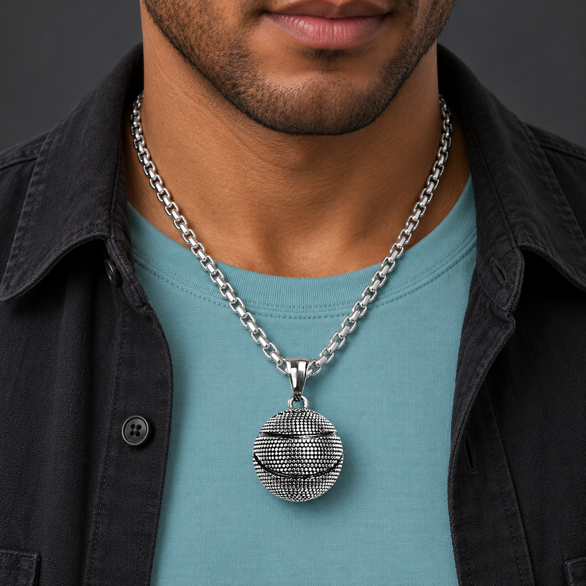 Textured ball pendant necklace worn with an aqua shirt and black jacket