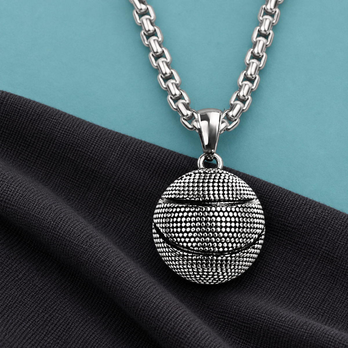 Textured ball pendant necklace styled on dark fabric