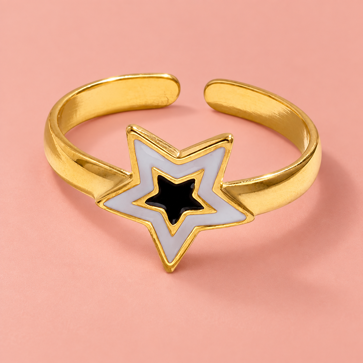Nested-star open-back ring on a blush surface