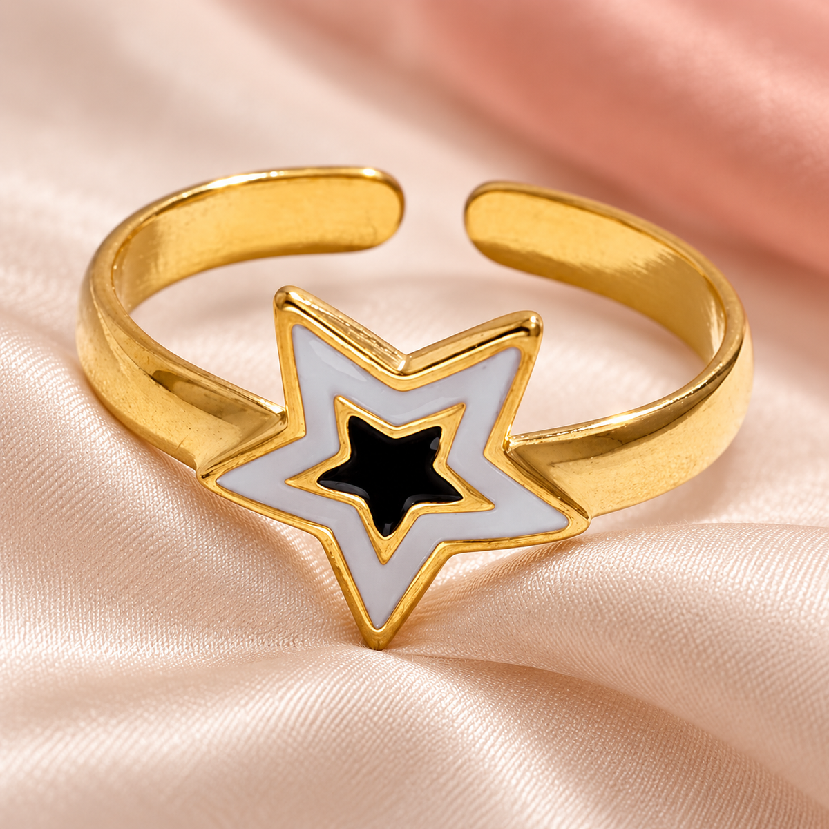 Nested-star ring resting on pale folded fabric
