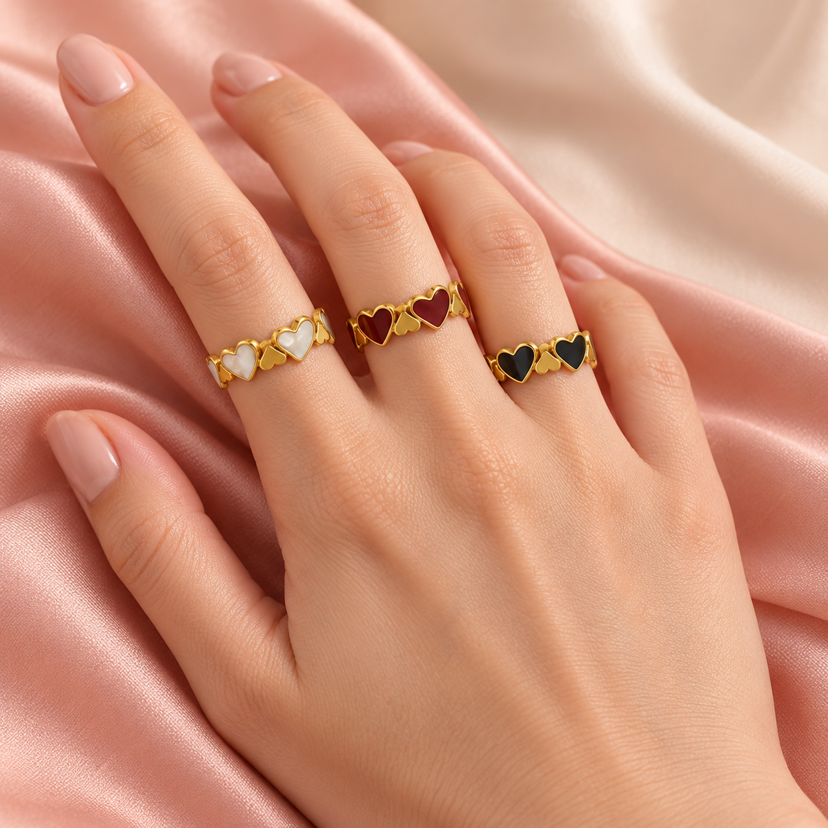 Three heart-link ring colourways shown together