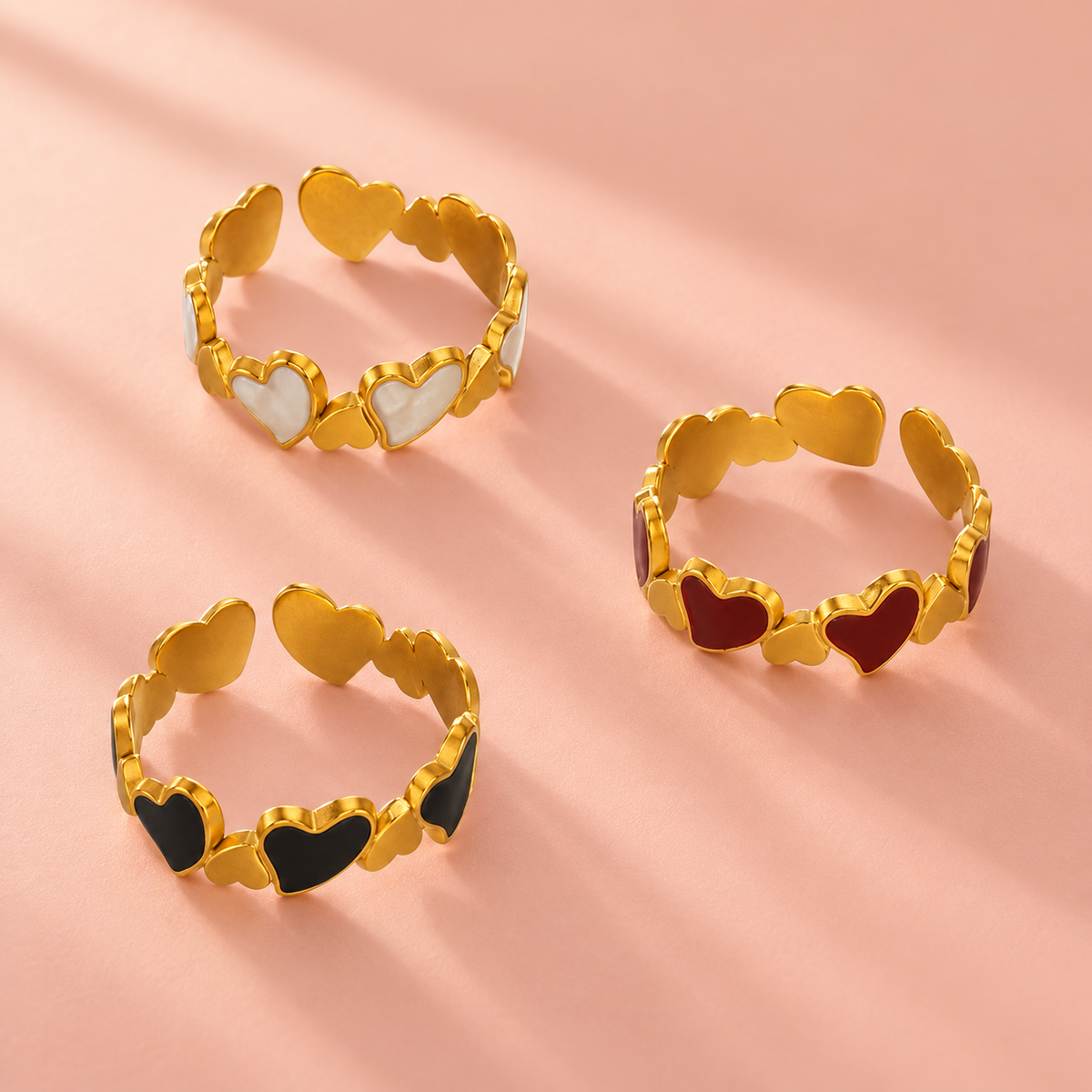 Three heart-link ring colourways shown together