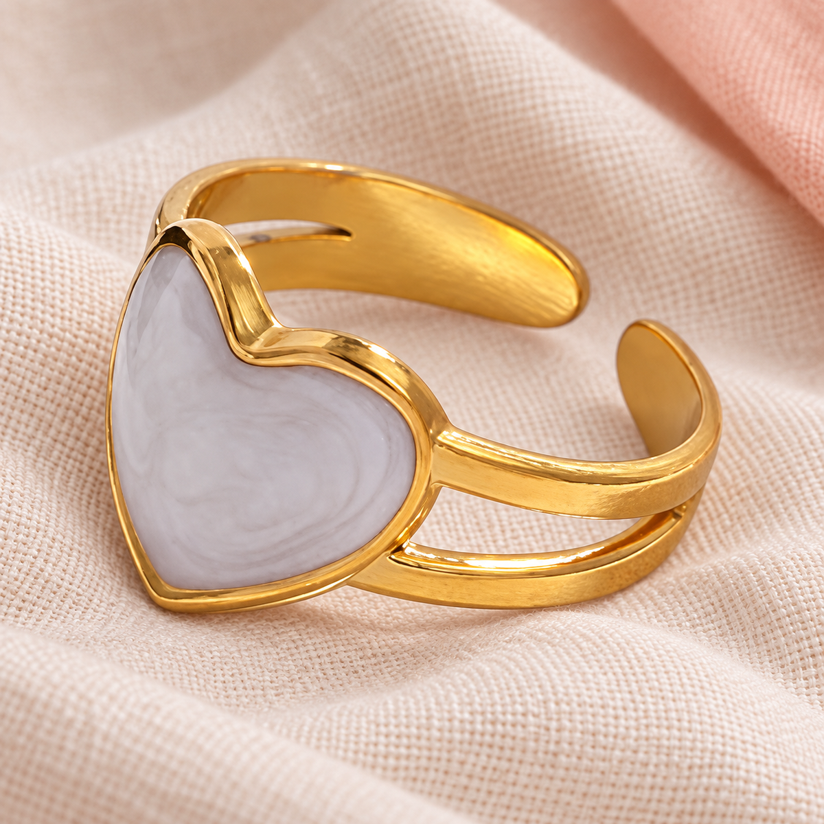 Heart-face ring arranged on pale woven fabric