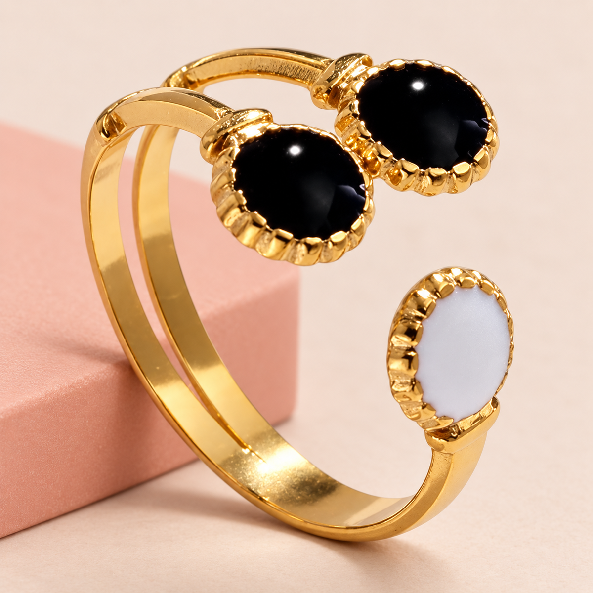 Black and pale motif ring beside a blush display block
