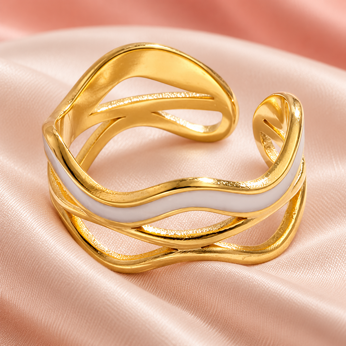 Wave-design ring arranged on pale folded fabric