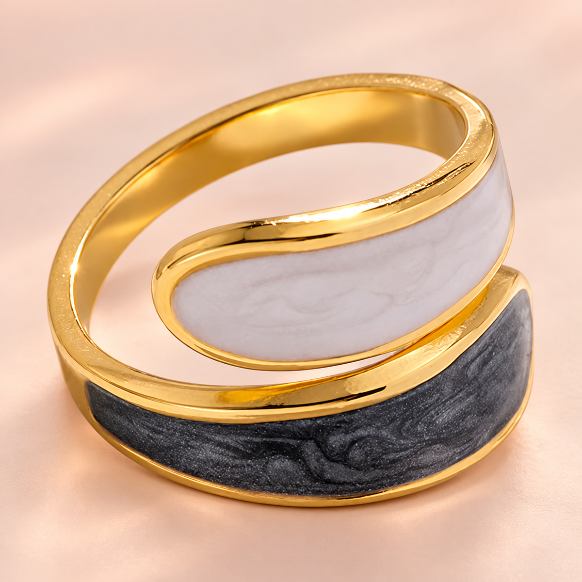 Gold-tone wrap-style ring with pale and dark curved panels