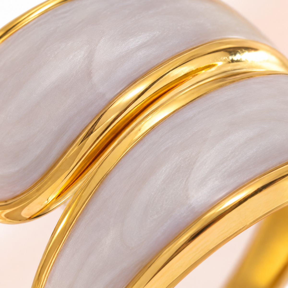 Close-up of the ring's pale curved panels and gold-tone edges