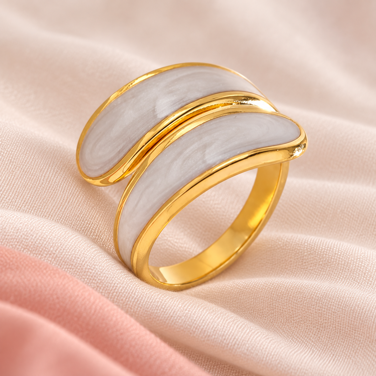 Pale-panel ring arranged on light folded fabric