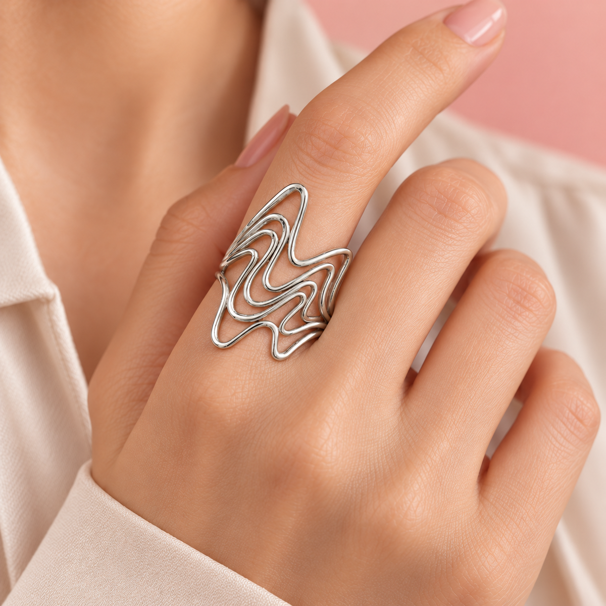 Silver-Tone Sculptural Ring Designs open-wave design worn on a hand