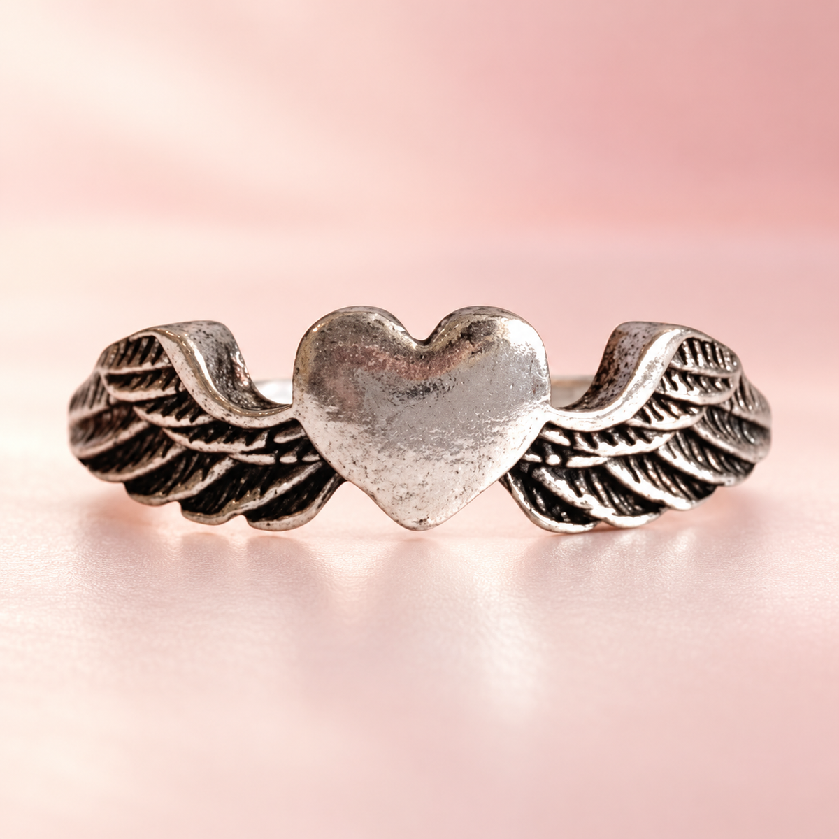 Silver-Tone Winged Heart Ring on a softly coloured background
