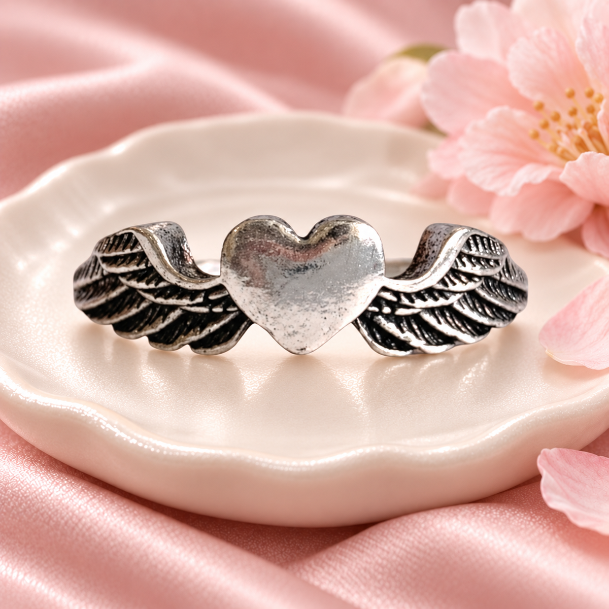 Silver-Tone Winged Heart Ring in a styled product photograph
