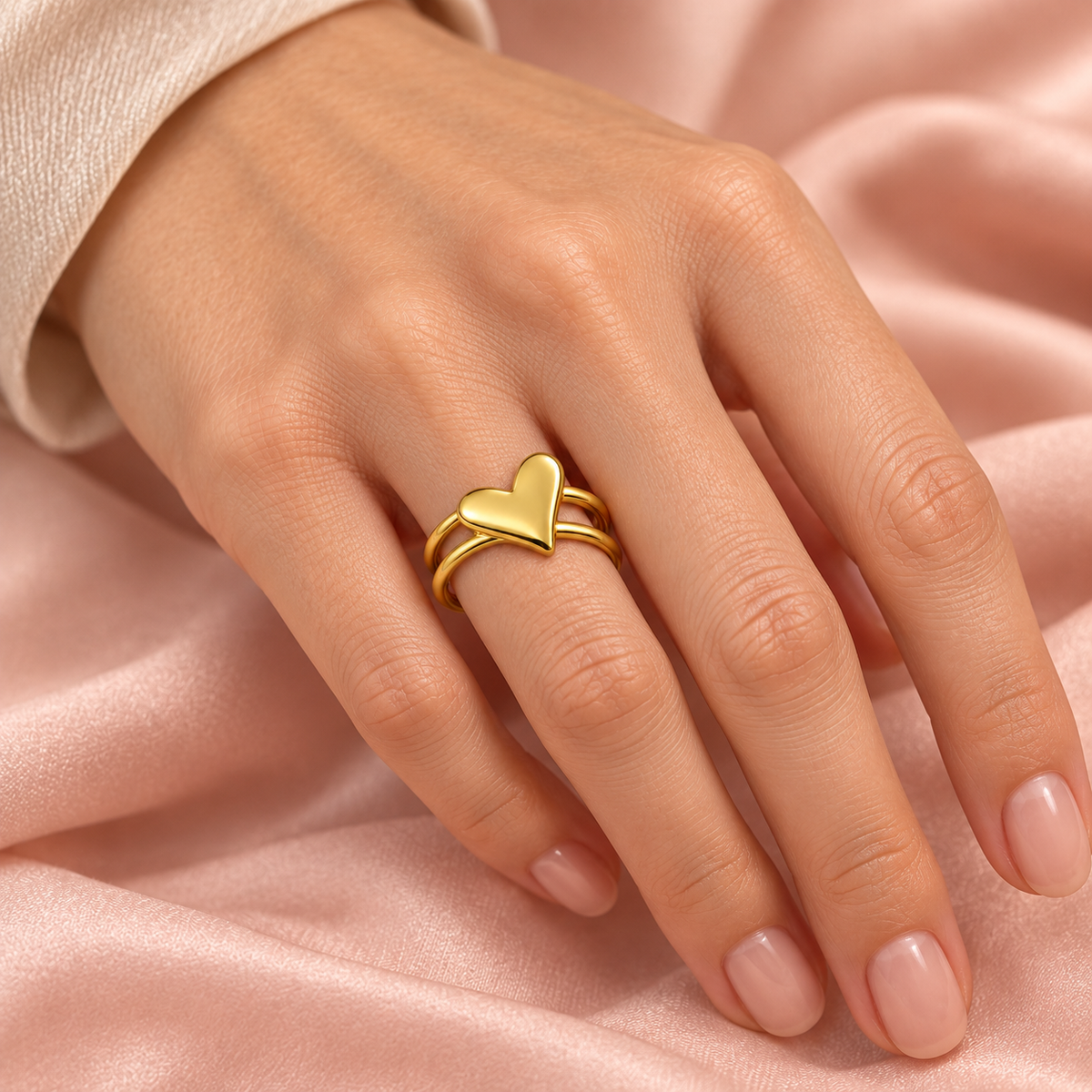 Gold-tone heart ring with an open double-rail band styled on a hand