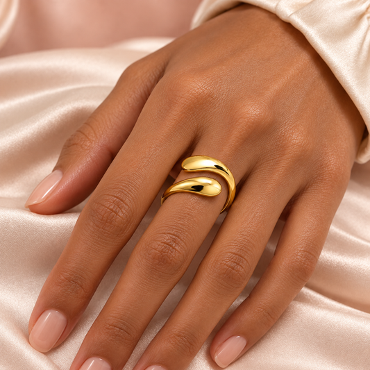 Gold-tone open bypass ring with rounded teardrop ends styled on a hand