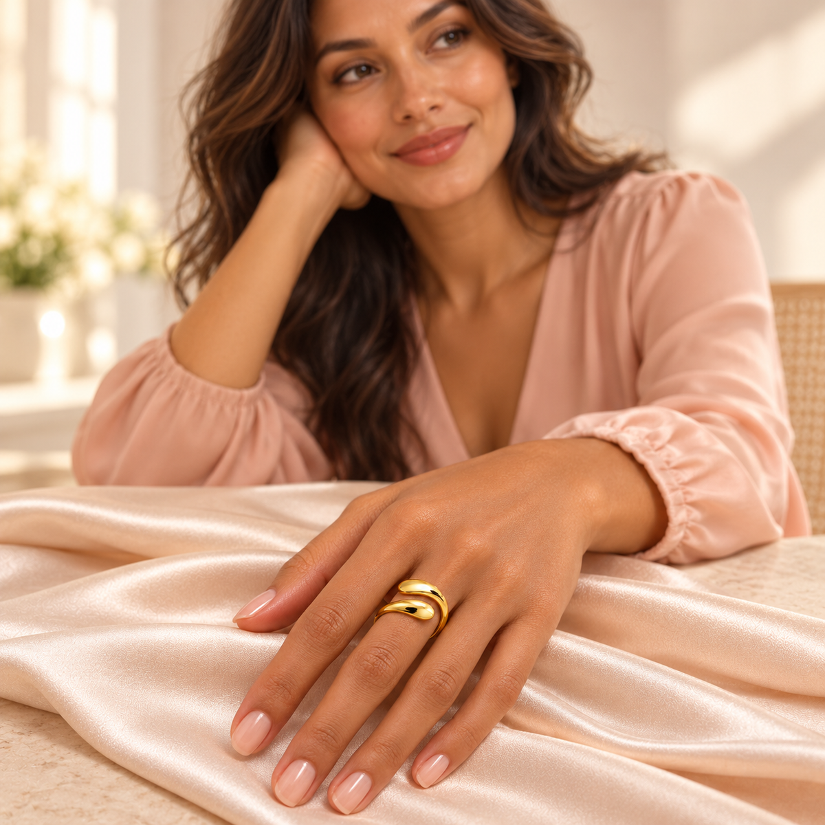 Gold-tone open bypass ring with rounded teardrop ends styled on a hand