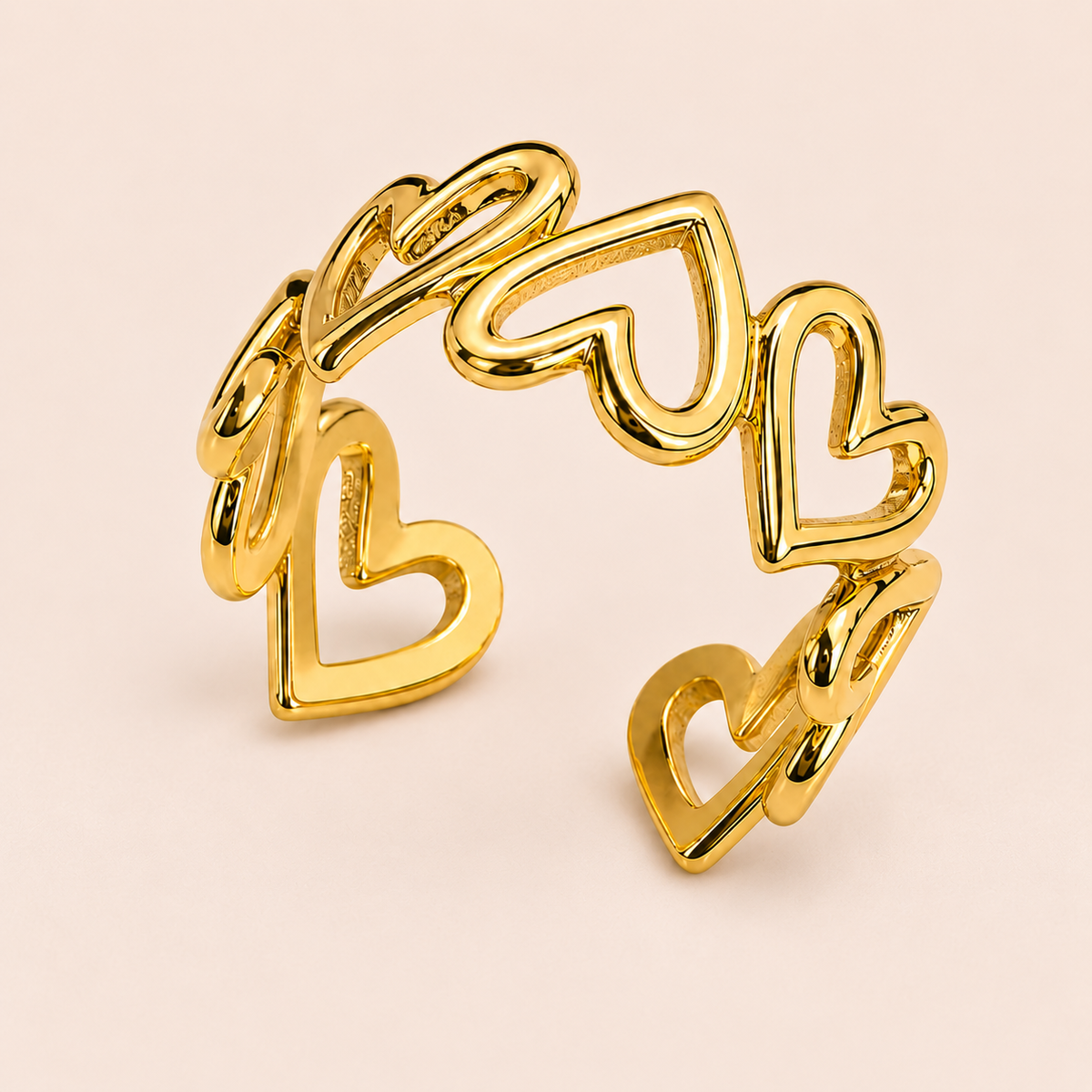 Gold-tone open ring with linked heart outlines