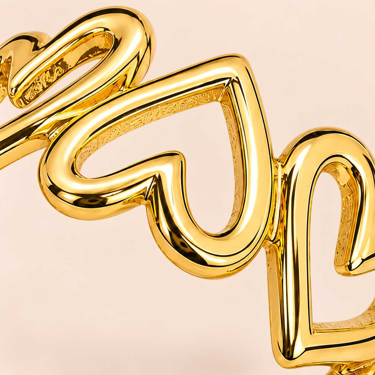 Gold-tone open ring with linked heart outlines