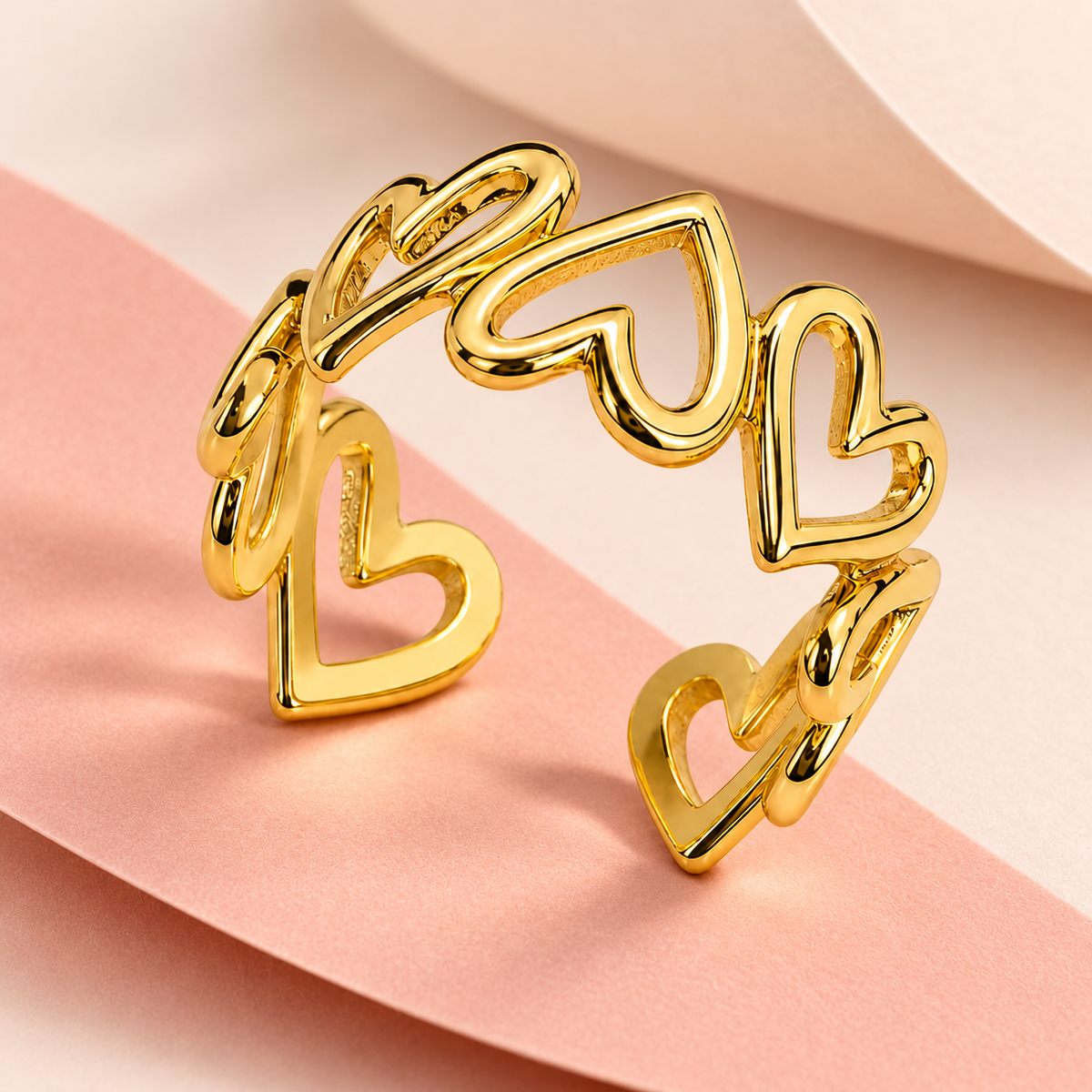 Gold-tone open ring with linked heart outlines