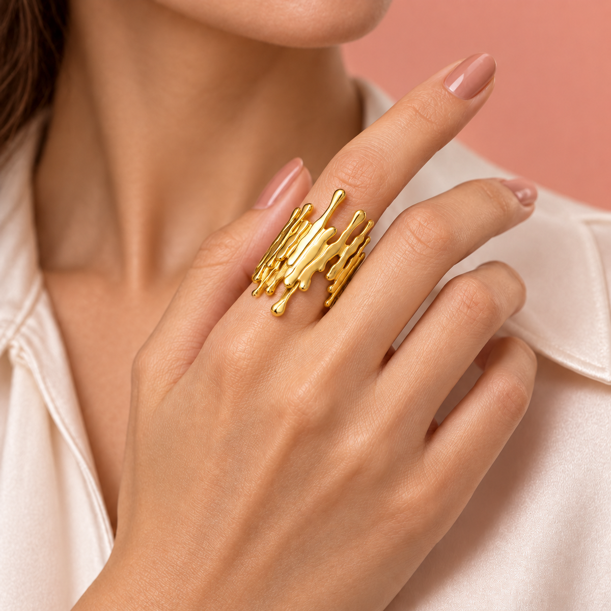 Gold-tone open ring with irregular drip-shaped edges styled on a hand