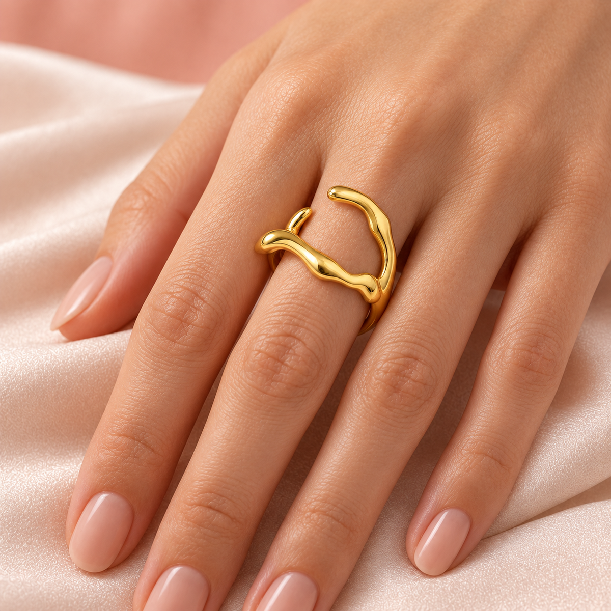 Gold-tone asymmetric open ring with wavy arms styled on a hand