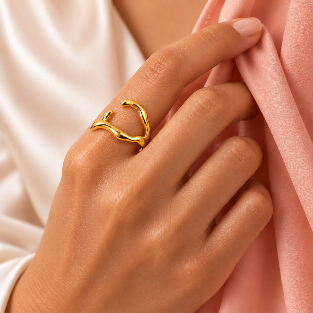 Gold-tone asymmetric open ring with wavy arms styled on a hand
