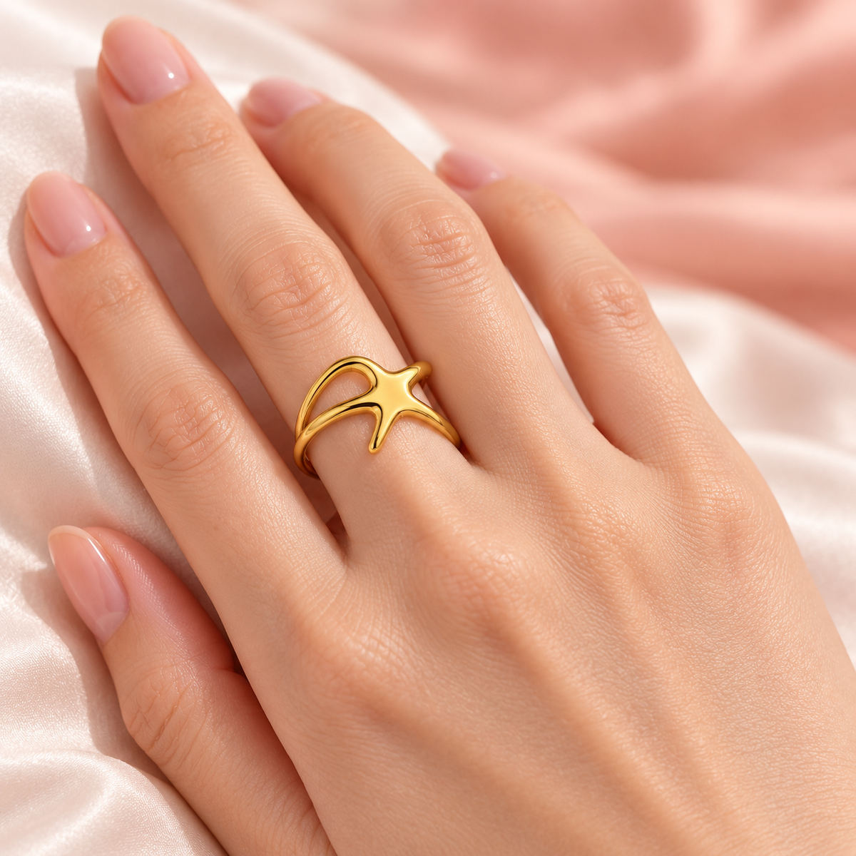 Organic Star Ring worn on a hand over satin