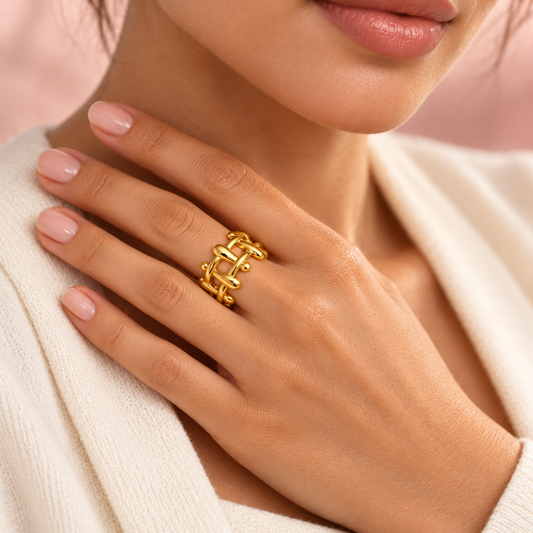 Gold-tone sculptural lattice ring, shown on a hand.