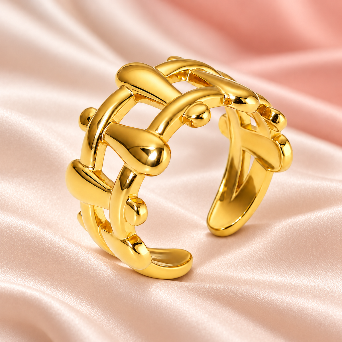 Gold-tone sculptural lattice ring, still-life view on fabric.
