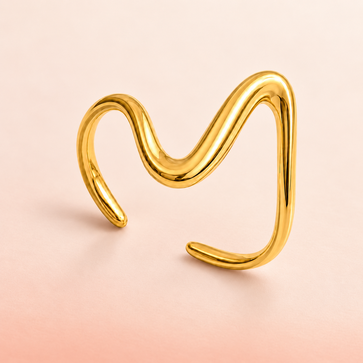 Gold-tone asymmetric wave ring, product view.
