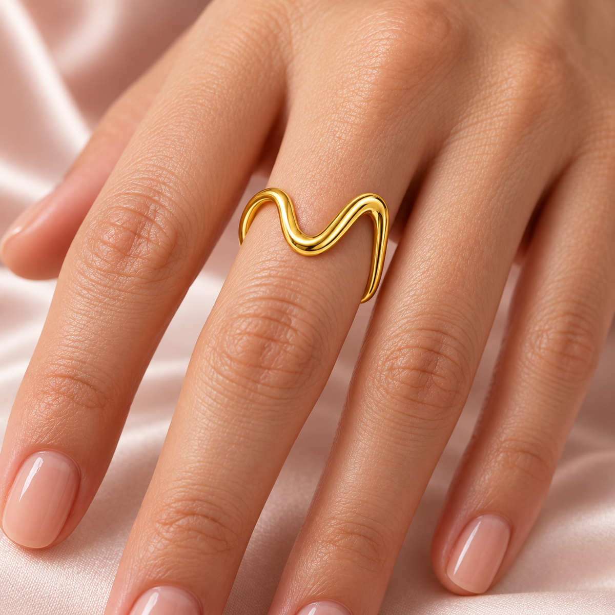 Gold-tone asymmetric wave ring, shown on a hand.